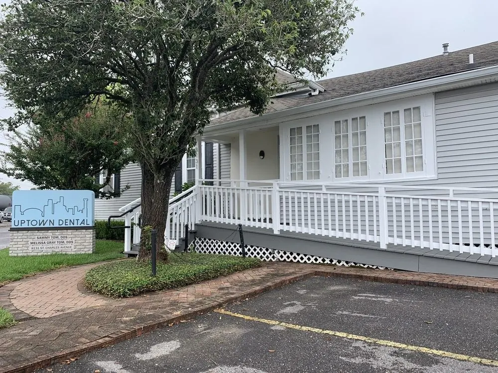 The Uptown Dental sign on St. Charles Avenue, naming Sammy Tom, DDS and Melissa Gray Tom, DDS, in front of the office.